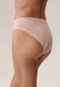 Jasnoróżowe bawełniane figi hipster z gładkim, elastycznym paskiem w talii. Posiadają prosty, bezszwowy design bez wzorów czy akcentów.