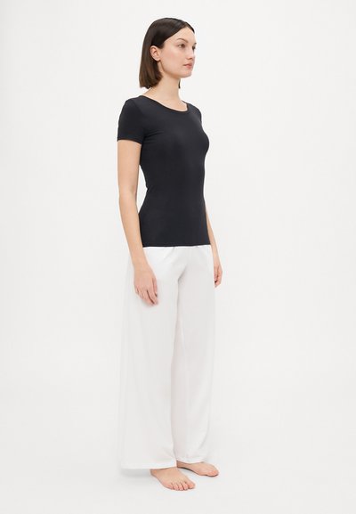 Black short-sleeve top with a round neckline, paired with white wide-leg trousers. Smooth texture, fitted design, and no visible patterns.