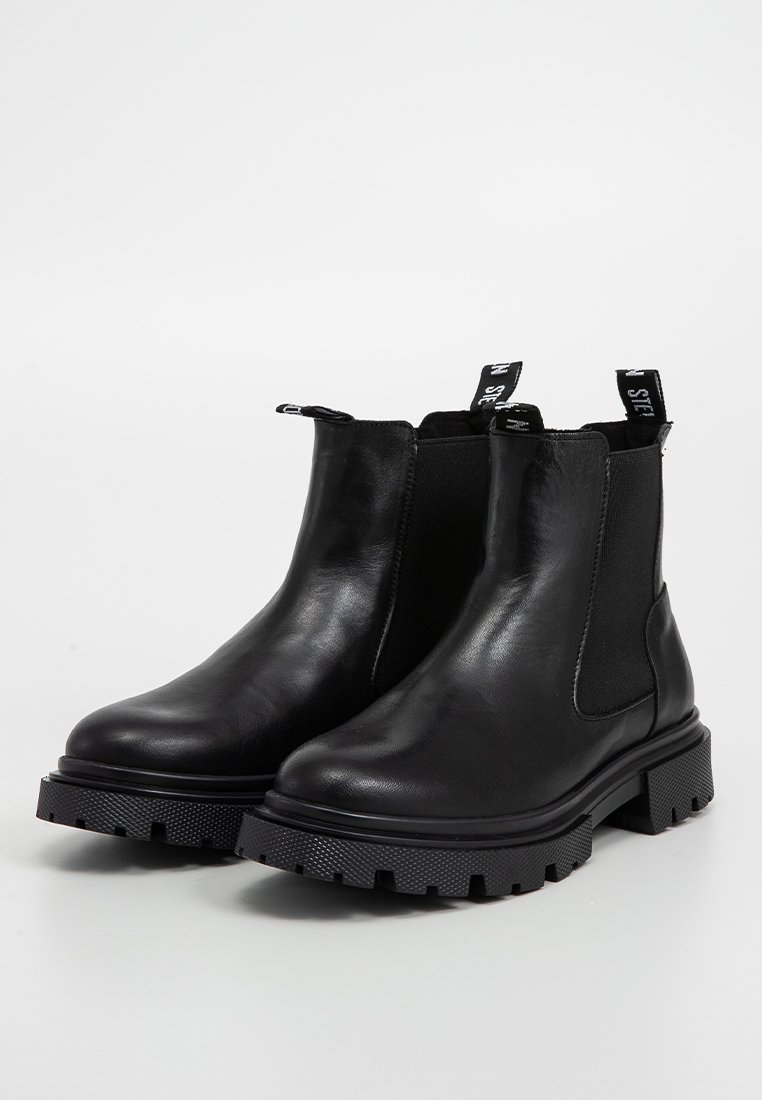 Stivali Chelsea neri in pelle con pannelli elastici laterali, linguette di presa, suole in gomma spesse e una texture liscia. Presentano un battistrada sagomato.