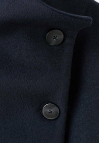 Tela de abrigo de lana azul marino con una textura suave, que presenta dos botones negros con un diseño de cuatro agujeros en la tapeta delantera.