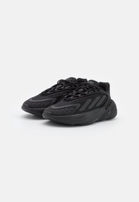 Scarpe athletic nere con tomaia texturizzata, dotate di suola ammortizzata, forma arrotondata e strisce tono su tono sui lati per dettagli di design.
