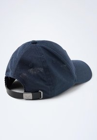 Gorra de algodón azul marino con visera curva, correa ajustable negra en la parte trasera y un acabado texturizado. Detalles de costura sutil en la parte superior.