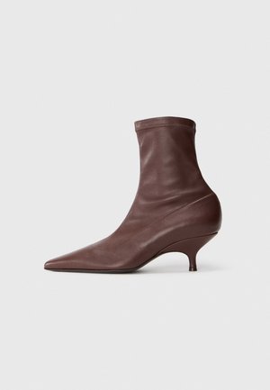 Brune læder ankelsko med spids tå, tætsiddende pasform og stilettohælsdesign med en glat tekstur.