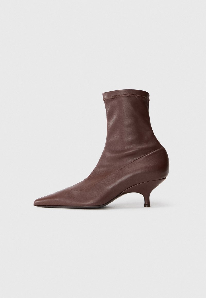Ruske nahkasaapikkaat, joissa on terävä kärki, tiukka istuvuus ja stiletto-korko, sekä sileä pinta.