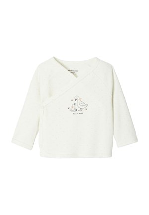 White long-sleeve baby shirt with small yellow dots, side snap buttons, and duckling and mother duck illustration with "toi + moi" text.