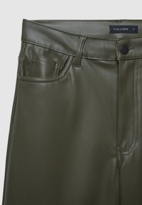 Kunstlederhose in Olivegrün mit glatter Textur; mit Bund, vorderer Tasche und Nahtdetails. Markenlabel sichtbar.