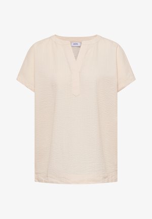 Krémová krátká halenka s texturou s výstřihem do V a kulatým límečkem, označená "Cecil" na výstřihu.