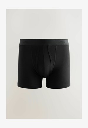 Boxer cortos de algodón negros con una suave cinturilla elástica que lleva el texto "NEXT SIGNATURE". Textura suave y diseño ajustado.