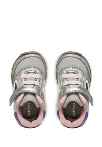 Sneakers argentate con una superficie lucida, dettagli rosa e cinturini in Velcro. Presentano un design testurizzato e aperture traspiranti sui lati.