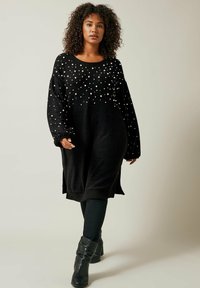 Abito maglione nero lavorato a maglia con una vestibilità comoda, decorato con perle bianche sparse. Le maniche lunghe e le fessure laterali completano il design.