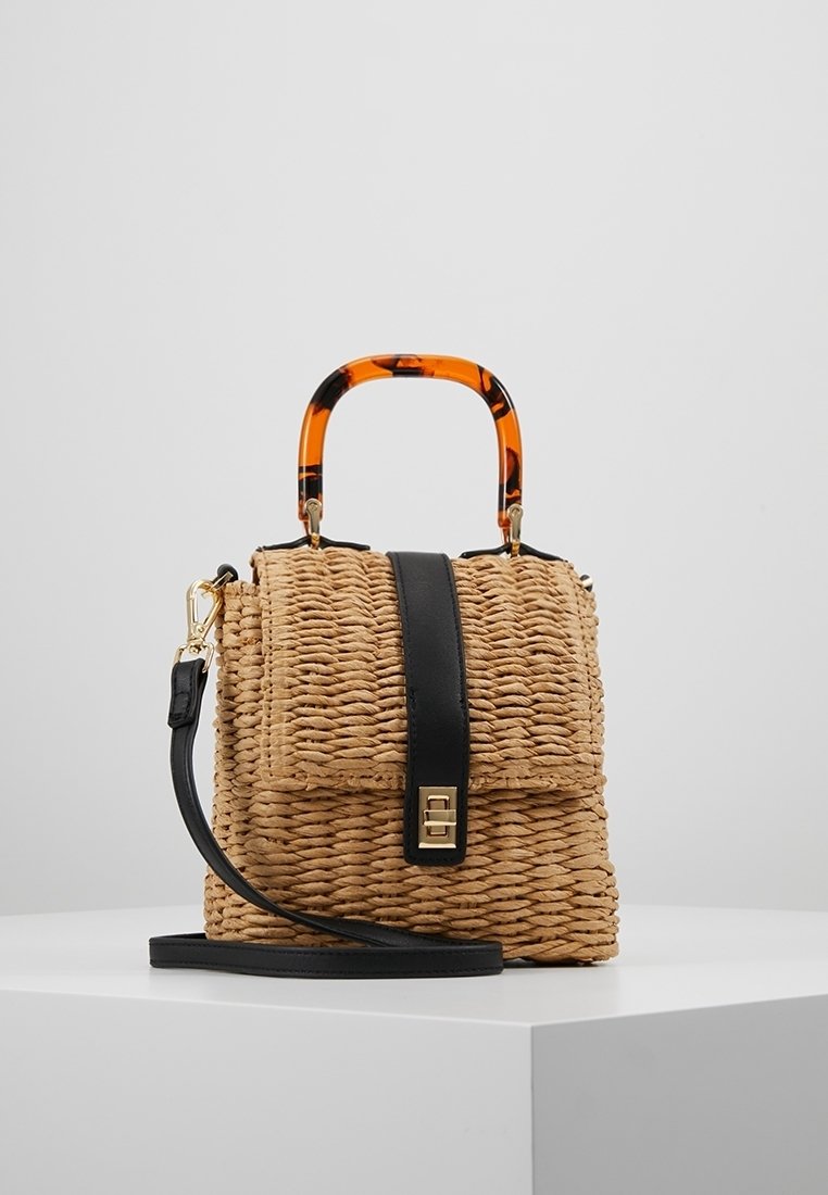 Borsa in paglia intrecciata con pattina in pelle nera, manico in acetato tartarugato e tracolla rimovibile. Presenta dettagli in hardware dorato.