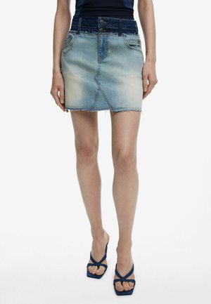 Jeansrok met een vervaagde lichtblauwe afwerking, rafelige zoom en een donkerblauwe tailleband. Bevat twee voorzakken en een slim fit ontwerp.