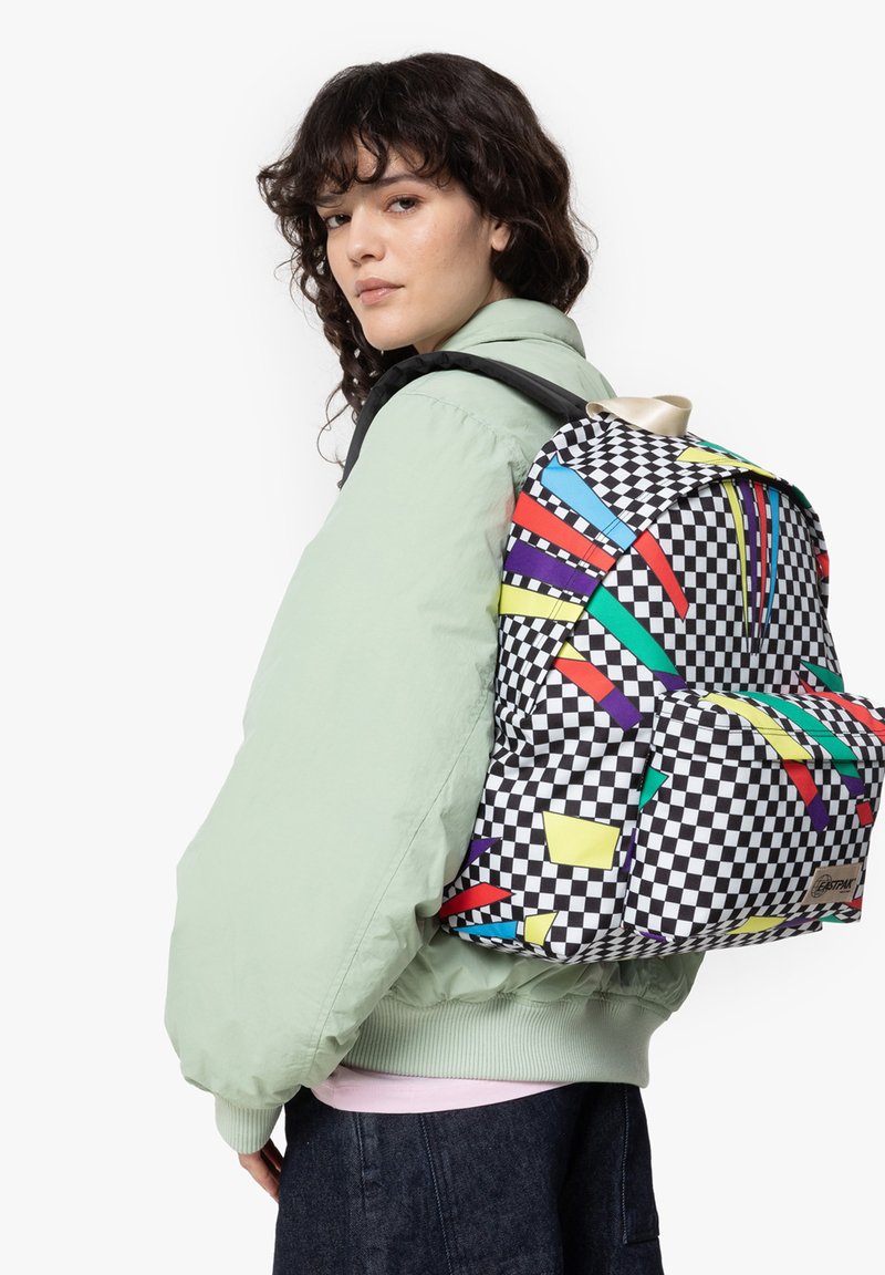 Backpack with a checkerboard pattern, accented by colorful geometric shapes in red, blue, yellow, and purple; nylon material, padded straps.