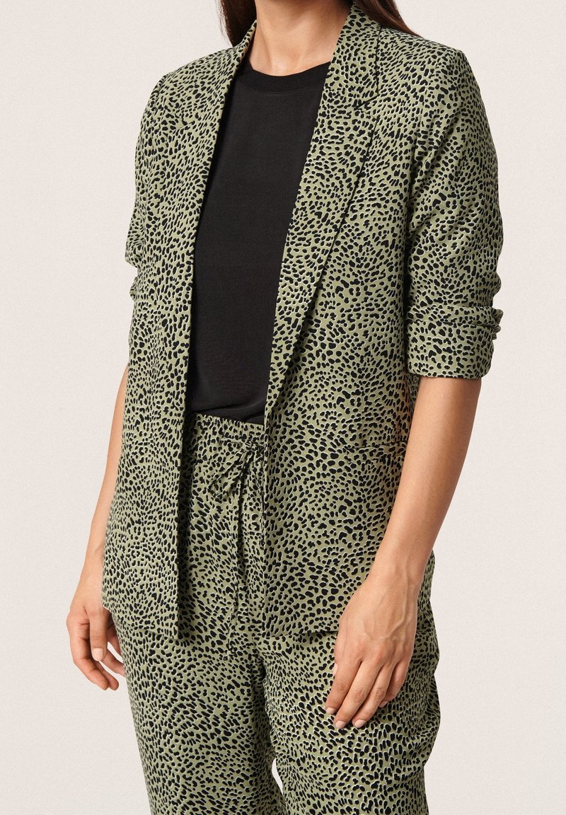 Grüner Leopardenmuster-Blazer mit lockerer Passform, gestaltet mit offenem Vorderteil, Reverskragen und hochgekrempelten Ärmeln. Dazu passende Hose.