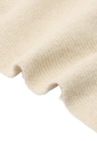 Kremowa tkanina o fakturowanej, prążkowanej powierzchni; charakteryzuje się miękkim, puszystym wykończeniem oraz naturalnymi, subtelnymi różnicami odcieni.