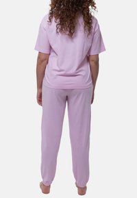 Set di pigiama in cotone rosa chiaro composto da una maglietta a maniche corte di vestibilità ampia e pantaloni con vita elastica e orli con risvolto.