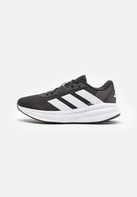Black running shoes with a breathable mesh upper, featuring three white stripes and a thick white midsole for cushioning. Rubber outsole.