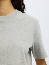 Lichtgrijs katoenen T-shirt met korte mouwen, een ronde hals en een zachte, gladde textuur. De stof lijkt licht gemêleerd.
