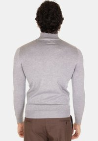 Maglione dolcevita grigio in un tessuto morbido e testurizzato, design aderente, con maniche lunghe e polsini a costine, visto da dietro.