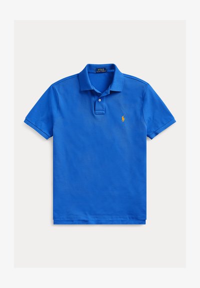 Blå polotrøye laget av myk bomull, med klassisk krage, toknapps lukking og en liten brodert logo på venstre bryst.