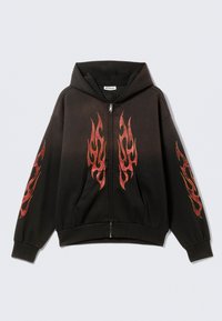 Sweat à capuche noir à fermeture éclair avec une grande poche avant. Présente des motifs de flammes rouges sur la poitrine et les manches. Confectionné en tissu doux avec une coupe décontractée.