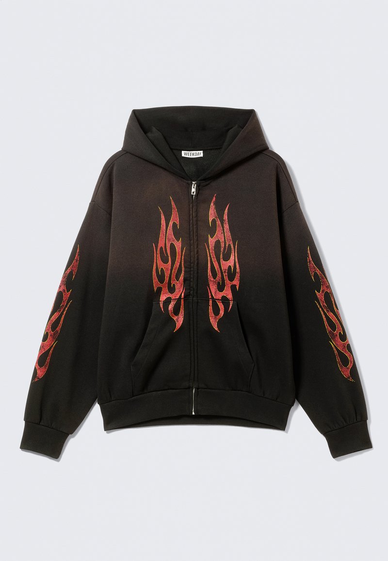 Sweat à capuche noir à fermeture éclair avec une grande poche avant. Présente des motifs de flammes rouges sur la poitrine et les manches. Confectionné en tissu doux avec une coupe décontractée.