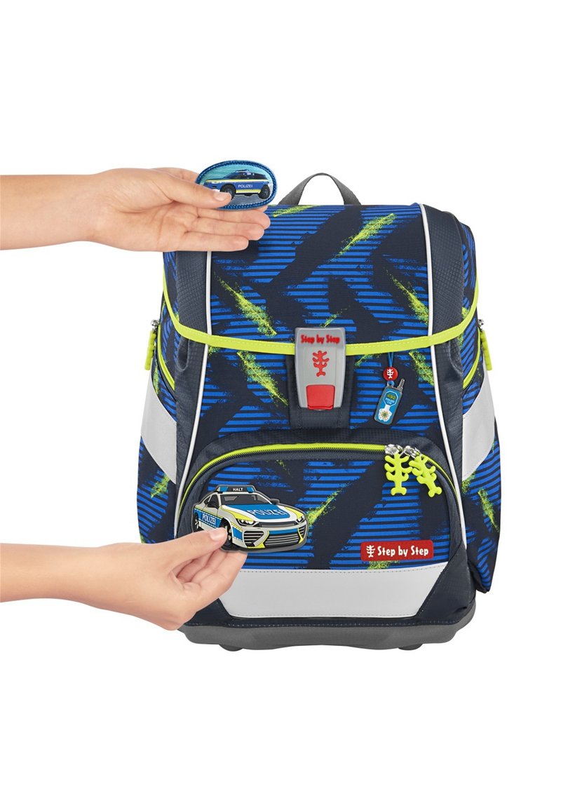 Sac à dos bleu et noir à motifs avec des accents verts, présentant un motif de voiture de police, des bretelles réglables et des bandes réfléchissantes pour la sécurité.