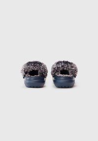 Et par marineblå slip-on klip klapper med grå fyldig for, set fra bagsiden på en hvid baggrund.