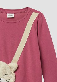 Rosa Langarmshirt mit einer cremefarbenen Akzenttrager sowie einer 3D-plüschigen Katzentasche mit gestickten Gesichtszügen. Weicher Stoff. Markenetikett sichtbar.