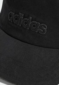 Černá kšiltovka vyrobená z texturované tkaniny, zdobená vyšitým logem "adidas" v mírně tmavším odstínu, s křivým kšiltem a šitými detaily.