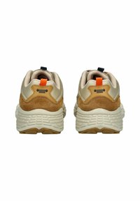 Beige Sneaker mit einem Wildleder-Fersenbereich, strukturiertem weißen Zwischensohle und kontrastierenden orangefarbenen und schwarzen Akzenten an den Laschen.
