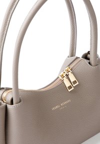 Sac à main en cuir gris avec deux poignées supérieures, matériel doré, fermeture éclair et surface texturée. Présente un logo embossé à l'avant.