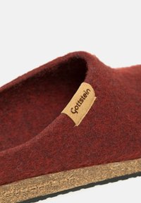 Red felt slipper with cork sole. Rounded shape, slip-on design, features a small leather tag with "Gotstein" branding.