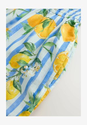 Tissu bleu clair avec des citrons jaunes et des motifs floraux, avec des rayures bleues alternées et un design de taille froncée.