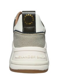 Weißer Sneakerabsatz mit grauem Wildlederpaneel, weißer Sohle mit geprägtem "Alexander Smith" und schwarzem Zugschlaufendruck in goldener Schrift "Alexander Smith".