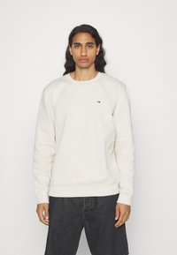Helle beige Sweatshirt aus Baumwolle, mit Rundhalsausschnitt und gerippten Bündchen. Kleines Logodetail auf der linken Brust.