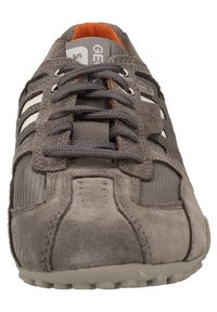 Szare zamszowe sneakersy z siateczkowymi akcentami, z białymi paskami, szarymi sznurówkami oraz texturedną podeszwą. Wnętrze w intensywnym pomarańczowym kolorze.
