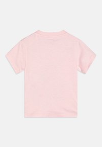 T-shirt en coton rose à manches courtes avec un col rond. Texture lisse, coutures minimales et couleur unie sans graphiques ni motifs.