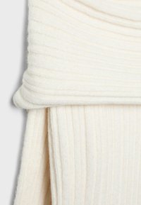 Krtačasta šal kremne barve iz mehke, teksturirane tkanine, z zgornjim delom, ki je prepognjen, in dolgimi, padajočimi konci. Brez vidnih vzorcev ali dodatkov.