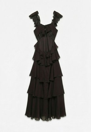 Rochie neagră fără mâneci pe niveluri, cu bretele cu volane, detaliu cu fundiță la decolteu și material stratificat și fluid pe toată lungimea.