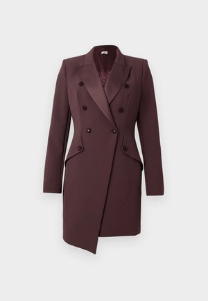 Kaksirivinen takki tummassa luumun värissä. Muotoiltu design rakenteellisilla hartioilla, terävillä kauluksilla ja kahdella suurella napilla. Tasainen, teksturoitu kangas.