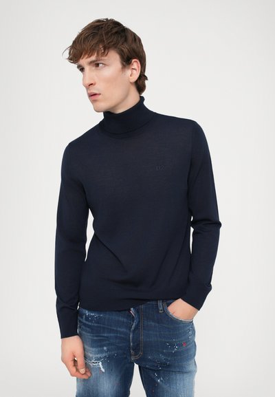 Navyblauer Rollkragenpullover aus weichem Material mit figurbetontem Schnitt, langen Ärmeln und dezentem Logo-Stick auf der Brust.