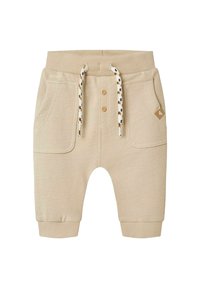 Beige katoenen peuterbroeken met een elastische tailleband, twee voorzakken, knoopsluiting en een trekkoord met een patroonaccent op de uiteinden.