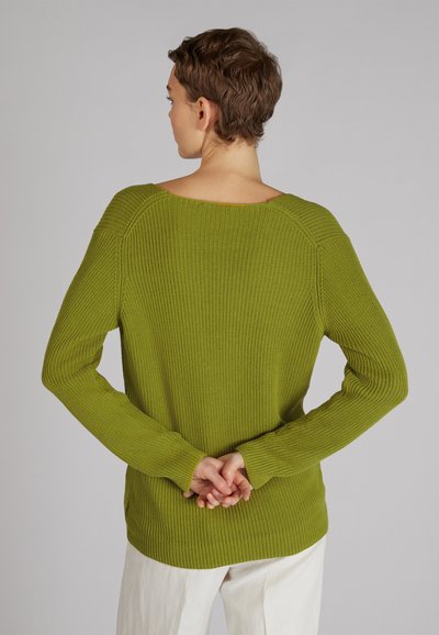 Maglione verde lavorato a maglia con una vestibilità rilassata, scollatura ampia e texture a coste. Maniche lunghe e un orlo posteriore leggermente più lungo.