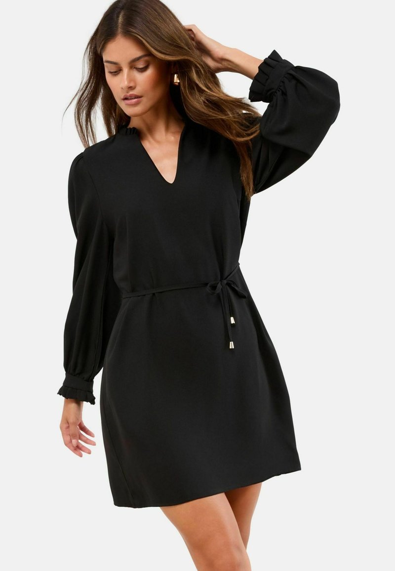 Schwarzes Kleid mit V-Ausschnitt, langen Puffärmeln und Zugband in der Taille. Mit rüschierten Ärmelabschlüssen und goldenen Akzenten.