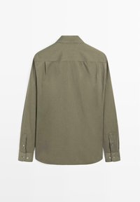 Camicia a maniche lunghe verde oliva, con colletto e polsini abbottonati, caratterizzata da una texture semplice e una vestibilità dritta. Design semplice senza fantasie.
