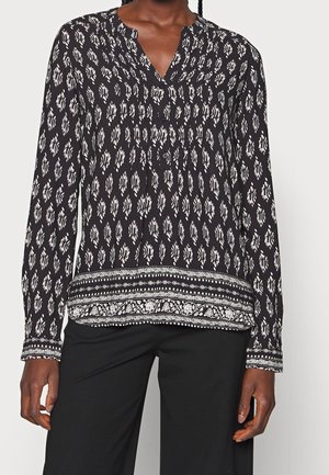 Sort langærmet bluse med hvidt blomstermønster, plisseret design, v-halskrave og dekorative kantdetaljer. Glat, let stof.
