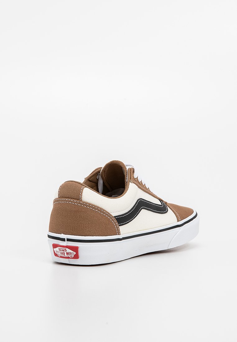 Zapatillas de lona marrón y crema con acentos negros, suela de goma blanca, forma redondeada y costuras en contraste; presenta el logo de Vans en el talón.