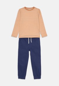Cămașă cu mânecă lungă, în dungi portocalie și crem, cu decolteu rotund, asortată cu pantaloni jogger din bumbac albastri, cu manșete elastice și talie cu șnur.