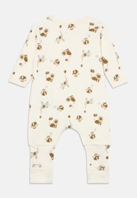 Krēmkrāsas bērnu kombinezons ar lauvas un pērtiķa tās ar baloniem visā virsmā. Izgatavots no mīksta auduma, ar garām piedurknēm un elastīgām aprocēm.